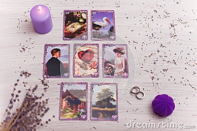 Divination cards alignment for love and family. Candle and wedding rings. Men and women relationships, astrology, fortune telling Editorial Stock Photo