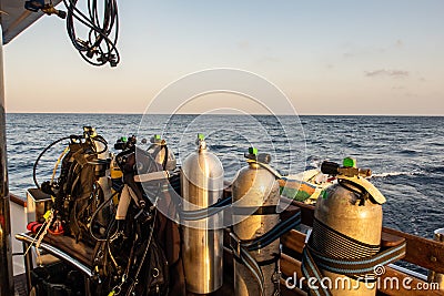 Diving gear with tanks, BCDs, regulators, weight belts assembled, on a diving boat with sea view in the background, Red Sea, Stock Photo