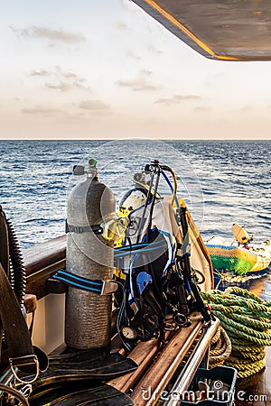 Diving gear with tanks, BCDs, regulators, weight belts assembled, on a diving boat with sea view in the background, Red Sea, Stock Photo