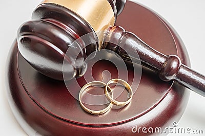 Divorce concept. Closeup view on gavel and wedding rings Stock Photo