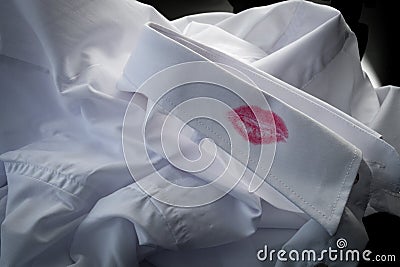 Divorce evidence, sexual affair and cheating husband concept with closeup on a shirt with red kiss lipstick of man that is a Stock Photo