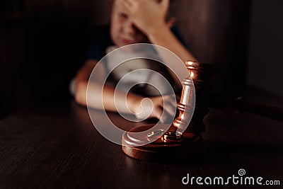 Divorce and separation concept. Wooden gavel, rings and sorrowful little boy with teddy bear. Family law Stock Photo