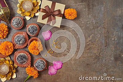 Diwali holiday concept with sweet traditional dessert, gift box and decorations on dark background. Top view, flat lay Stock Photo