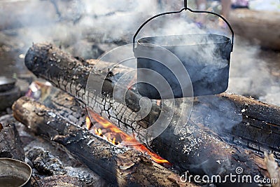 A dixy on the fire is on stones in the forest Stock Photo