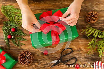 DIY Gift Wrapping. Woman wrapping beautiful christmas gifts on rustic wooden table. Overhead view christmas wrapping. Stock Photo