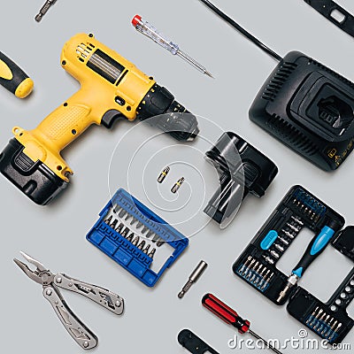 DIY home tool minimal concept. Pattern made of yellow cordless drill, battery charger, tool kits, screwdrivers, stainless multi Stock Photo