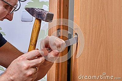 DIY installation of latch in door, groove is cut out with chisel for lock plate Stock Photo