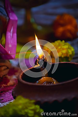 A diya is an oil lamp made from clay or mud with a cotton wick dipped in ghee. Diyas are native to the Indian subcontinent and Stock Photo