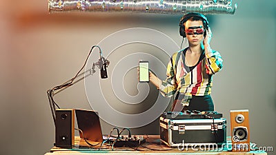 DJ artist shows greenscreen template while she uses turntables Stock Photo