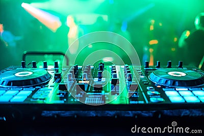 DJ booth at night club party for music mixing with green blurred background Stock Photo