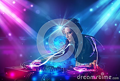 Dj girl mixing music with powerful light effects Stock Photo