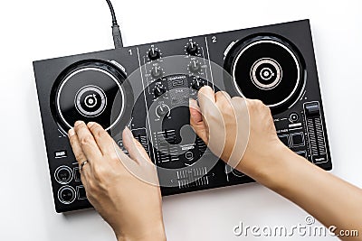 DJ hands mixing music on DJ Digital mixing controller top view on white background Stock Photo