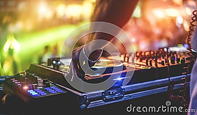 Dj mixing outdoor at beach party festival with crowd of people in background - Summer nightlife view of disco club outside - Soft Stock Photo