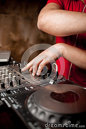 The DJ`s hand on the DJ mixer. Dj on the turntables. DJ`s hand on a DJ mixer close-up Stock Photo