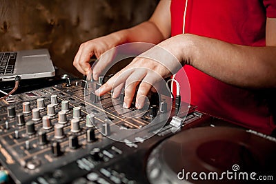 The DJ`s hand on the DJ mixer. Dj on the turntables. DJ`s hand on a DJ mixer close-up Stock Photo