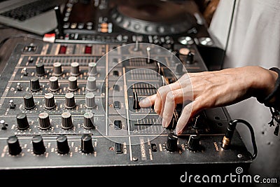 The DJ`s hand on the DJ mixer. Dj on the turntables. DJ`s hand on a DJ mixer close-up Stock Photo