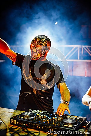 DJ with Skull mask playing electronic music at Summer Party Fest Stock Photo