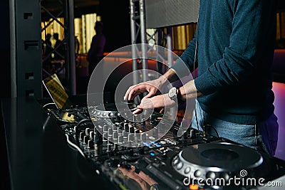 DJ with Turntables playing music at mixer Stock Photo