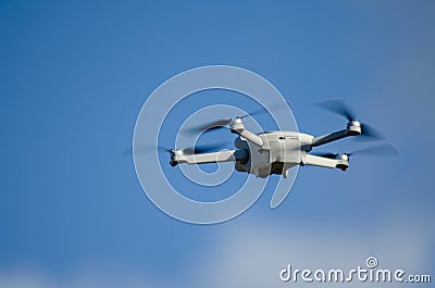 DJI Mavic Mini 3 drone in flight, blue sky in the background Editorial Stock Photo