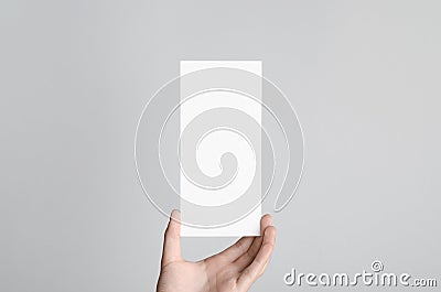 DL Flyer Mock-Up - Male hands holding a blank flyer on a gray background Stock Photo