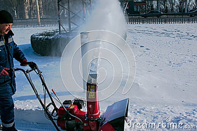 City Municipal Service cleans city streets after heavy snowfall. A man cleans deep snow with Editorial Stock Photo