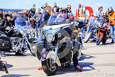 Guys and girls on beautiful expensive motorcycles open the motorcycle season. Bikers in helmets and leather jackets ride on motorc Editorial Stock Photo