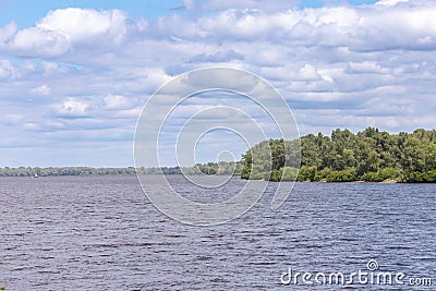Dnipro river and green island under a cloudy blue sky on a sunny summer day Stock Photo