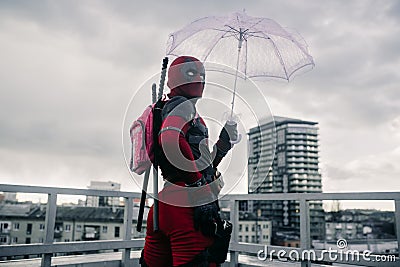 DNIPRO, UKRAINE - MARCH 28, 2019: Deadpool cosplayer posing with weapon and umbrella Editorial Stock Photo