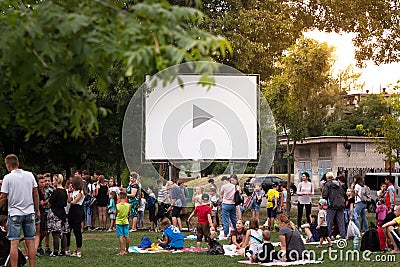 DNIPRO, UKRAINE - 08.01.2020: Open air cinema, movie. Crowd of people on the background of a large movie screen, outdoors Editorial Stock Photo