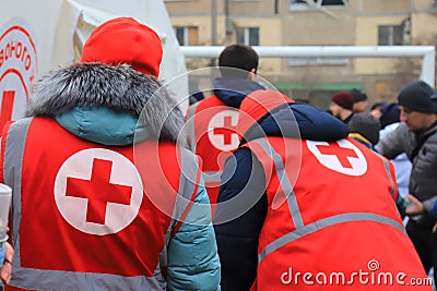 Dnipro Ukraine. Red Cross volunteers help wounded near destroyed house after Russian missile attack. Red cross badge on uniform of Editorial Stock Photo