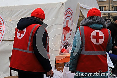 Dnipro Ukraine. Red Cross volunteers help wounded near destroyed house after Russian missile attack. Red cross badge on uniform of Editorial Stock Photo