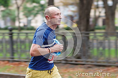 Senior man running on a city street during 21 km distance of ATB Dnipro Marathon Editorial Stock Photo
