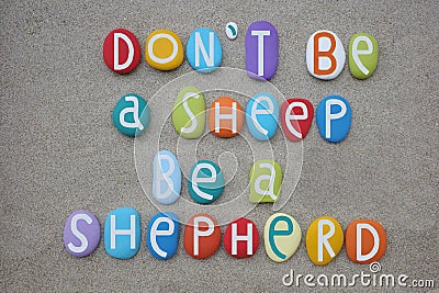 Do not be a sheep, be a shepherd, creative quote composed with multi colored stone letters over beach sand Stock Photo