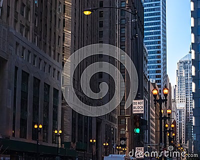 `DO NOT BLOCK INTERSECTION` sign on dark, eerily lit city street in Chicago Loop Stock Photo