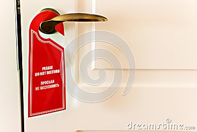 Do not disturb sing on door, with same text on russian. Stock Photo