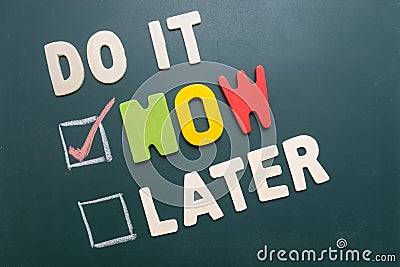 Do It Now or Later with checkbox and red check on blackboard Stock Photo