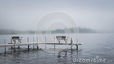 Dock with benches on foggy lake in Bemidji Minnesota Stock Photo