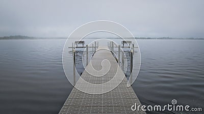 Dock with benches on foggy lake in Bemidji Minnesota Stock Photo