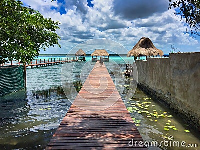 Dock with palm roof above a multicolor lake in Bacalar, Mexico. Stock Photo
