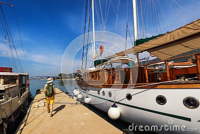 Docked ship in port. Docking on the pier in the Mediterranean. Yacht parked at dock. Tourist with backpack walking on the pier Stock Photo