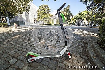 Dockless electric kick scooters from a scooter-sharing system parked on a sidewalk Stock Photo