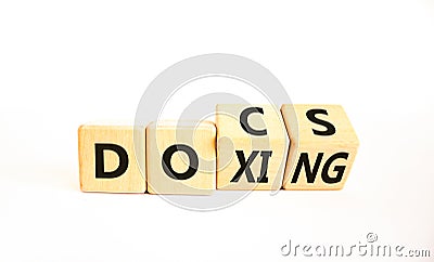 Docs or doxing symbol. Concept words Docs Doxing on wooden block. Beautiful white table white background. Business docs or doxing Stock Photo