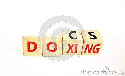Docs or doxing symbol. Concept words Docs Doxing on wooden block. Beautiful white table white background. Business docs or doxing Stock Photo