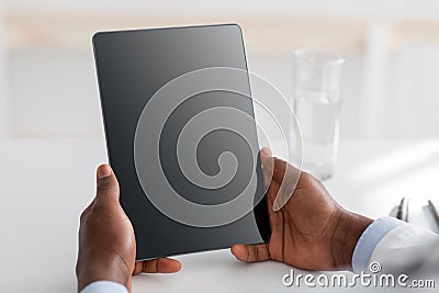 Doctor advice and technology for treat. African american doctor using digital tablet with black blank screen, mockup for Stock Photo