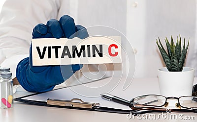 Doctor advises. Nutritionist or medical worker holds a VITAMIN C sign, healthy lifestyle concept Stock Photo