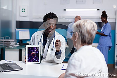 Doctor of african american ethnicity holding digital tablet Stock Photo
