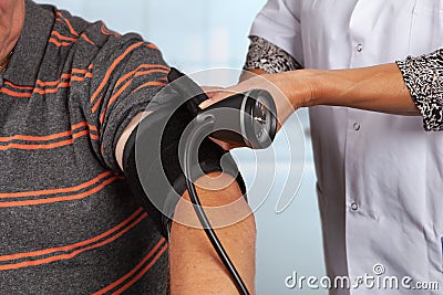 Doctor applies cuff for blood pressure measurement Stock Photo