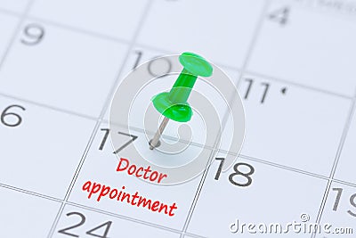 Doctor appointment on a calendar with a green push pin to remind Stock Photo