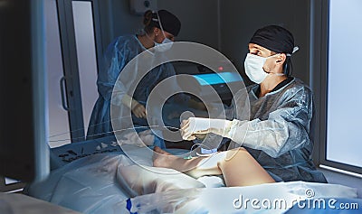 Doctor and an assistant in operating room for surgical venous va Stock Photo