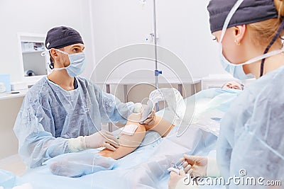 Doctor and an assistant in operating room for surgical venous va Stock Photo